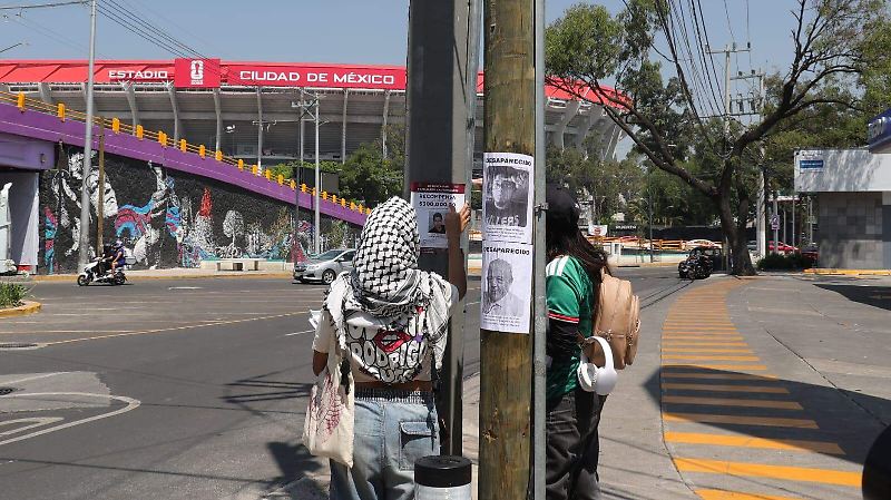 Con un ajolote y una pala “mundialista” familias pegan fichas de búsqueda cerca del Estadio Azteca